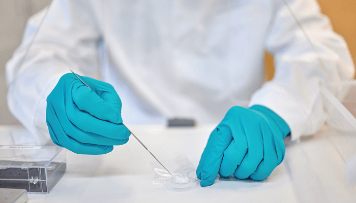 Close up of the gloved hands of a lab worker using Nanoform